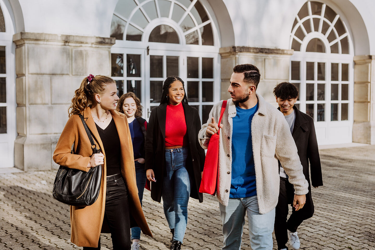 Wirtschaftswissenschaften studieren. Eine Gruppe von Studierenden unterhalten sich vor dem Eingang der HWR Berlin. Foto: Lukas Schramm